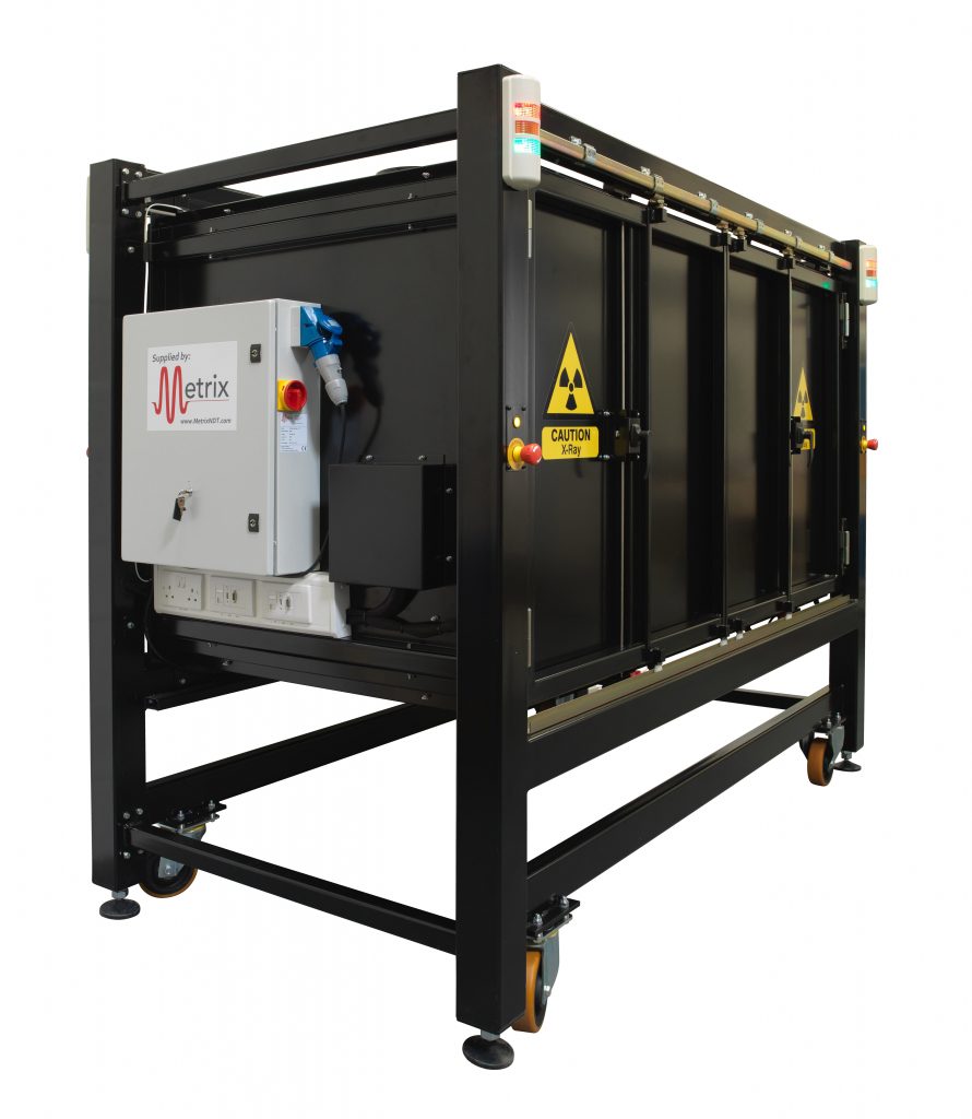 Side view of a black Metrix x-ray cabinet with warning stickers and annunciator